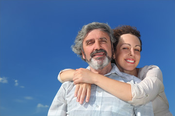 portrait of  woman embracing father from back and smiling