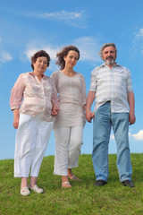 family of adult woman and her parents standing on lawn