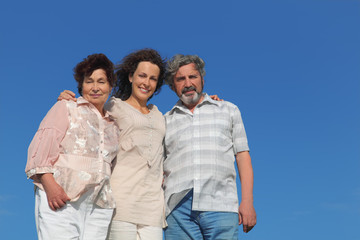 adult daughter and parents embracing and smiling