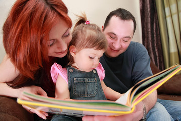 Fototapeta premium father and daughter in denim jumpsuit reads book