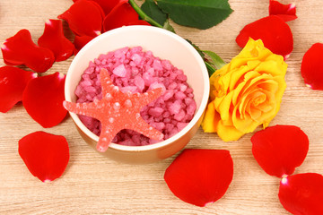 Bath aromatic salt, rose and petals  on wooden background
