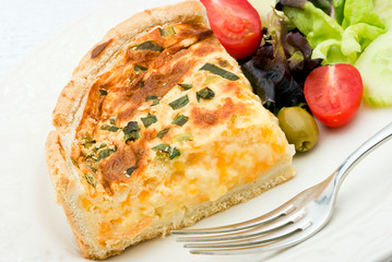 Quiche with salad on a white plate.