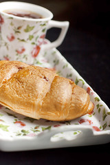 croissant on the plate with tea cup