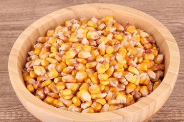 Yellow corn grain in wooden bowl