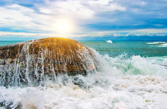 Sunset and a rock covered with water.