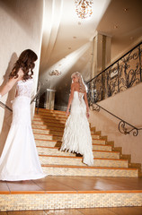 Two girls in a beautiful wedding dress on the stairs