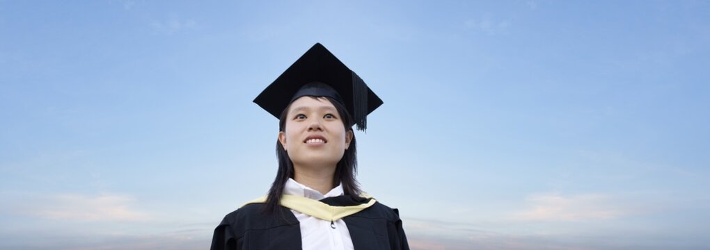 Happy asian lady graduate with panoramic sky background