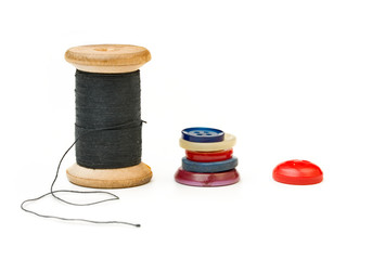 Thread bobbin and buttons isolated on white background