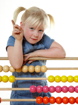 Cute blond child counting at school