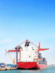 Red container ship under large blue sky