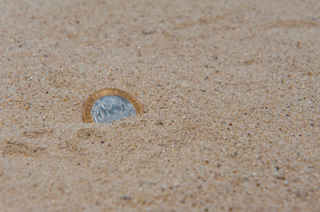 Russian anniversary coin in sand