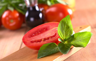 Fresh basil leaves with tomato halves
