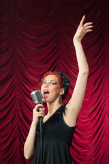 beautiful redhead woman singing into vintage microphone