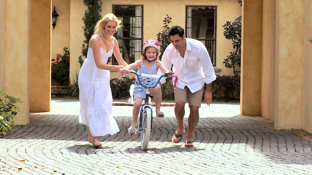 Child with Multi-Ethnic Parents Learning to Ride a Bicycle