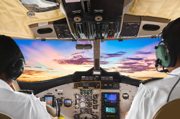 Pilots in the plane cockpit and sunset
