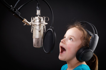 kleines mädchen singt in ein mikrofon