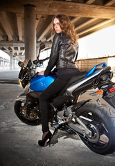 Naklejka na ściany i meble Young beautiful caucasian woman posing on blue sport bike