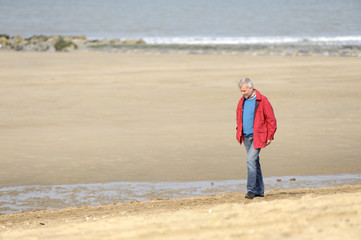 Obraz premium mature adult man walking on the beach
