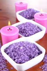 Fototapeta na wymiar Lavender spa salt and lavender candles on a wooden background