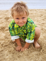 Cute little boy on the beach near the sea