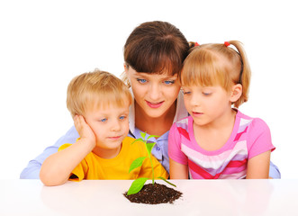 Young mother explaining children about the plant