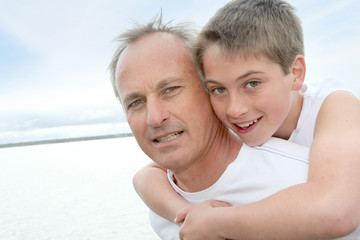 Fototapeta premium Portrait of man carrying young boy on his back