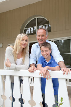 Portrait Of Family Standing On Their Home Terrace