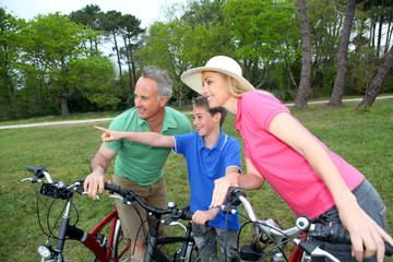 Fototapeta na wymiar Family on a bike ride standing by a lake