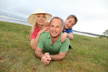 Fototapeta premium Portrait of happy family laying in grass