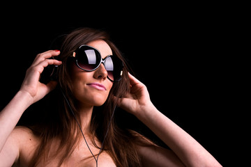 Portrait of happy girl listening music in headphones. Studio sho