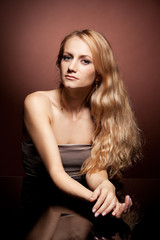 Naklejka premium Fashion portrait of sensual young woman on brown background