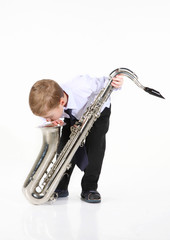 little boy and the big saxophone. It is isolated.