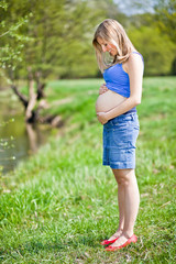 Naklejka na ściany i meble Pregnant woman outdoor spring time