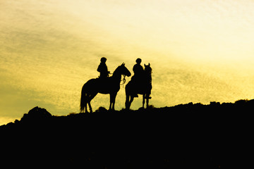 Fototapeta na wymiar Silhouette of two horses with riders