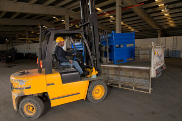 Forklift operator loading truck at factory