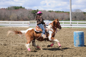 Teenage girl barrel racing