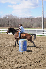 Young woman barrel racing