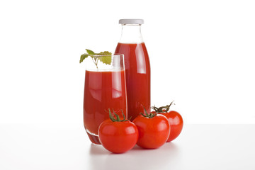 Tomatensaft im Glas mit Flasche und Tomaten