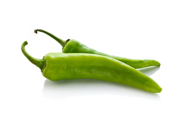 Two green chili on white background