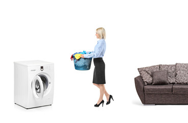 Woman with a laundry basket going towards a washing machine
