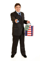 Smiling businessman with shopping bags giving credit card