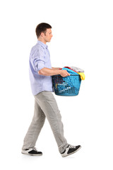 Full length portrait of a young man carrying a laundry basket
