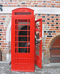 Obraz premium woman in red hat look out from phonebox