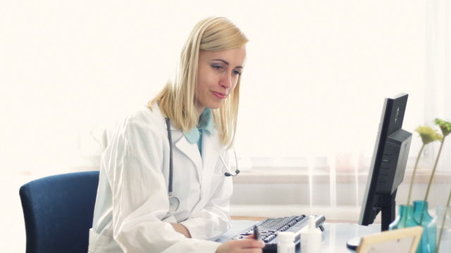 Sick female doctor blowing her nose