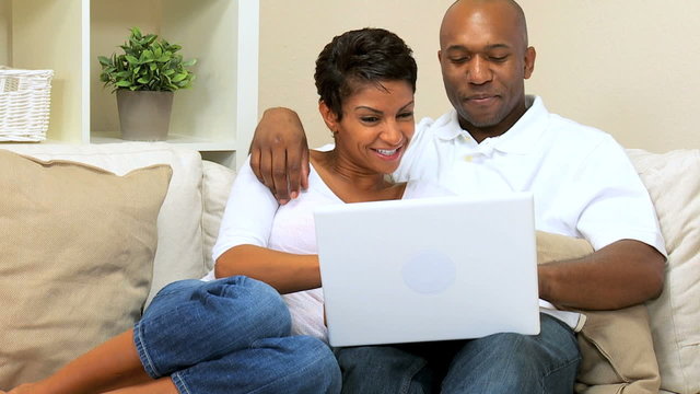 Young Ethnic Couple Using Laptop at Home