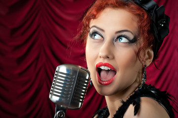beautiful redhead woman singing into vintage microphone