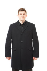 Attractive young man in black coat on white