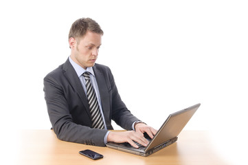 Junger Manager überlegt am Laptop