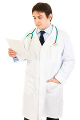 Concentrated medical doctor reading document isolated on white.