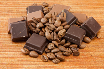 Chocolate and coffe beans on wooden plate